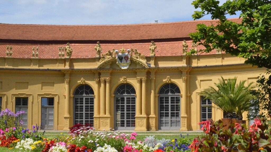 Fassade der Orangerie in Erlangen mit Blumenrabatten im Vordergrund